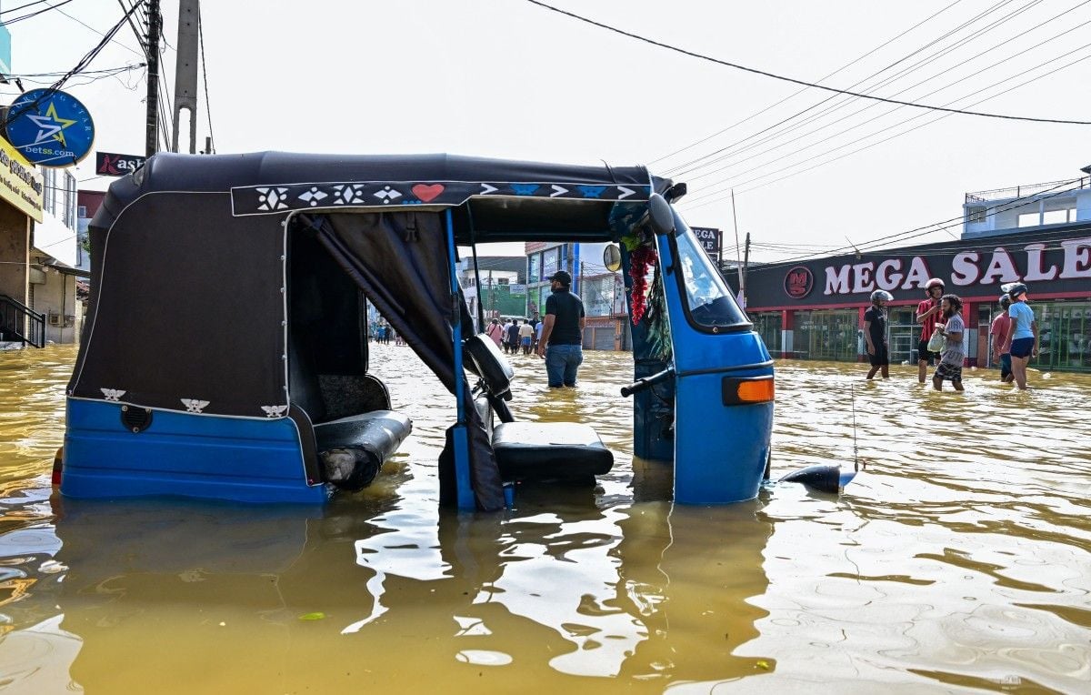 1444x920_an-auto-rickshaw-lies-stranded-as-people-wade-through-a-flooded-street-after-heavy-rainfall-in-wellampitiya-on-the-outskirts-of-colombo-on-november-30-2025-sri-lankan-authorities-battled-rising-flo.jpeg